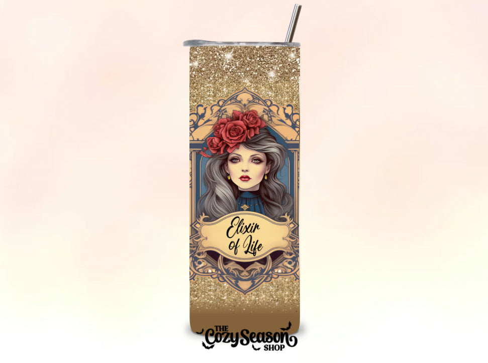 Tumbler with decorative design and text 'Elixir of Life' on a gradient background