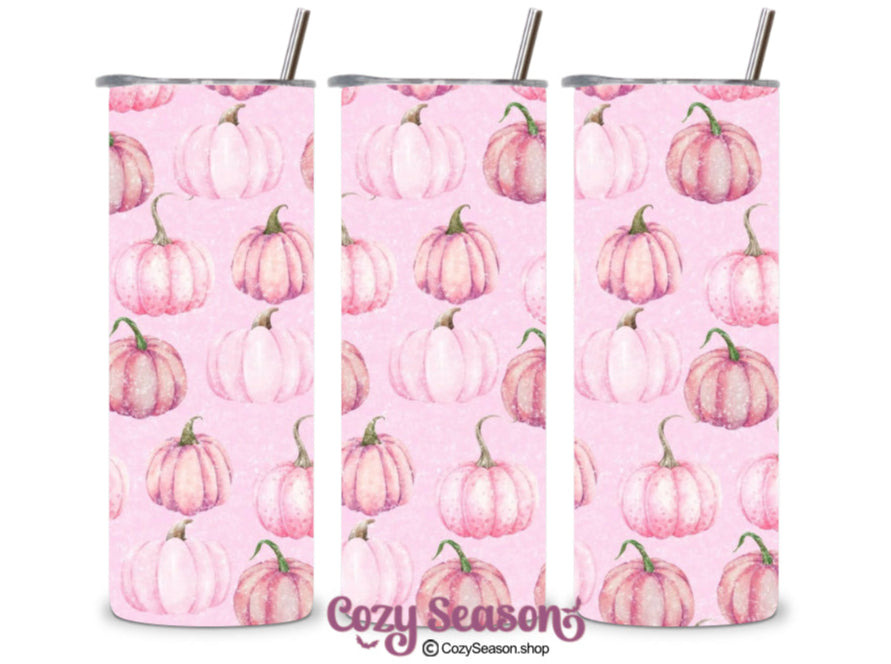 A set of three stainless steel tumblers with a pink background and printed pumpkin designs, each equipped with a clear acrylic lid.