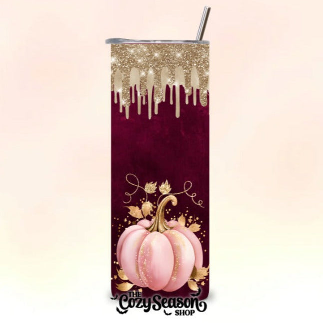 A 20oz skinny stainless steel tumbler with a glitter print design featuring autumn-themed graphics such as pumpkins and leaves, labeled 'COZY SEASON'.