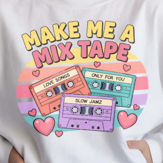 T-shirt with colorful cassette tape design and text 'Make Me a Mix Tape' on a white background