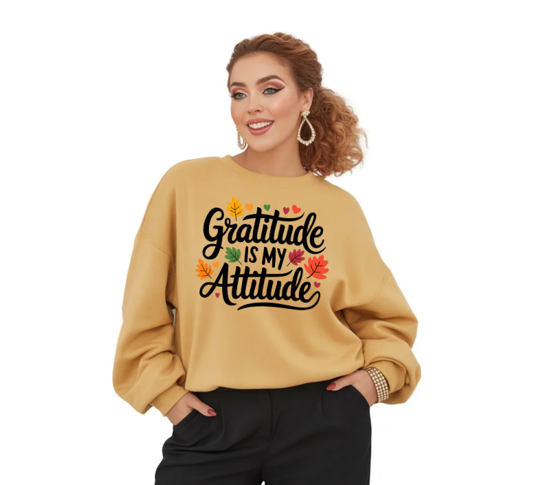 Woman wearing a beige sweatshirt with 'Gratitude is my attitude' text and autumn leaves design on a white background