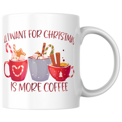 White mug with Christmas-themed design and text 'All I want for Christmas is more coffee' on a white background.