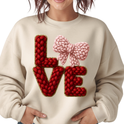 Woman wearing a cream sweater with red and pink 'LOVE' design 