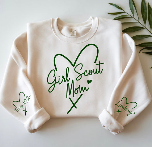 White sweatshirt with 'Girl Scout Mom' text and green hearts on a light background