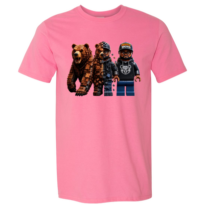 A pink short-sleeve crewneck t-shirt featuring a graphic print of two pixelated bears and a pixelated minifigure on the front, displayed against a solid white background.