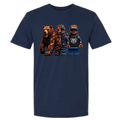 A navy blue short-sleeve t-shirt with a graphic print of three blocky, toy-like figures resembling LEGO minifigures, including a brown bear and two human figures, shown on a plain white background.