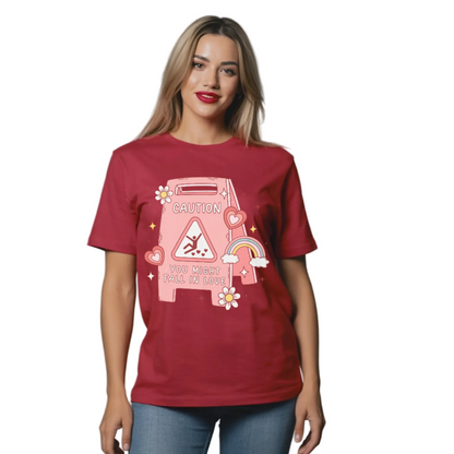 Woman wearing a red t-shirt with a graphic design on a plain background