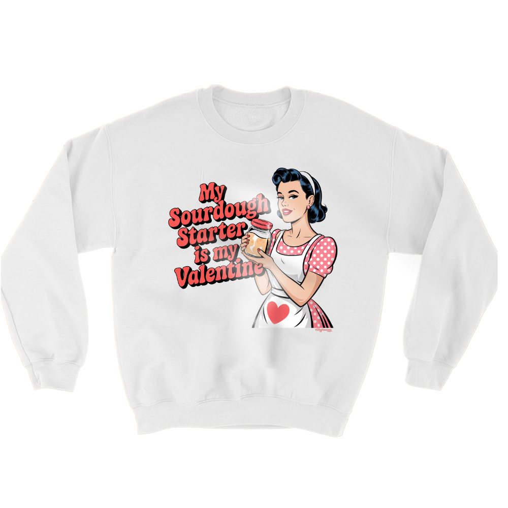 A WHITE SWEATSHIRT WITH A COMIC ART STYLE DRAWING OF A PIN UP GIRL WEARING A RED AND WHITE POLKADOT DRESS AND A WHITE APRON. THE PIN UP GIRL IS HOLDING A JAR OF SOURDOUGH STARTER. THE RED TEXT: MY SOURDOUGH STARTER IS MY VALENTINE 
