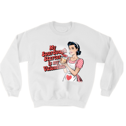 A WHITE SWEATSHIRT WITH A COMIC ART STYLE DRAWING OF A PIN UP GIRL WEARING A RED AND WHITE POLKADOT DRESS AND A WHITE APRON. THE PIN UP GIRL IS HOLDING A JAR OF SOURDOUGH STARTER. THE RED TEXT: MY SOURDOUGH STARTER IS MY VALENTINE 