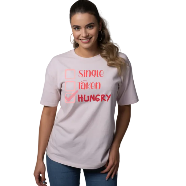 Woman wearing a light pink t-shirt with text: SINGLE, TAKEN, HUNGRY WITH checkboxes on a WHITE BACKGROUND. 