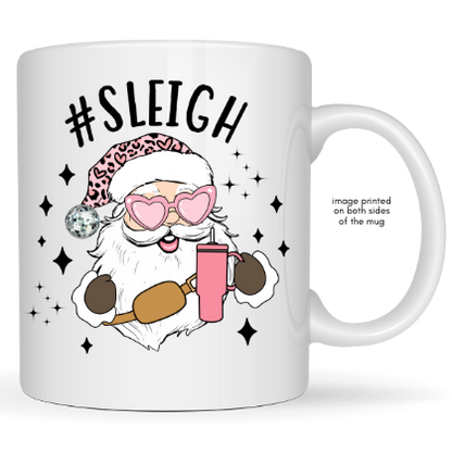 White mug with a graphic of a Santa-like character holding a pink drink, wearing sunglasses and a leopard print hat, with '#Sleigh' text above.