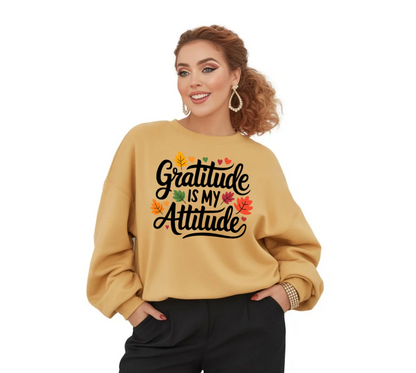 Woman wearing a beige sweatshirt with 'Gratitude is my attitude' text and autumn leaves design on a white background