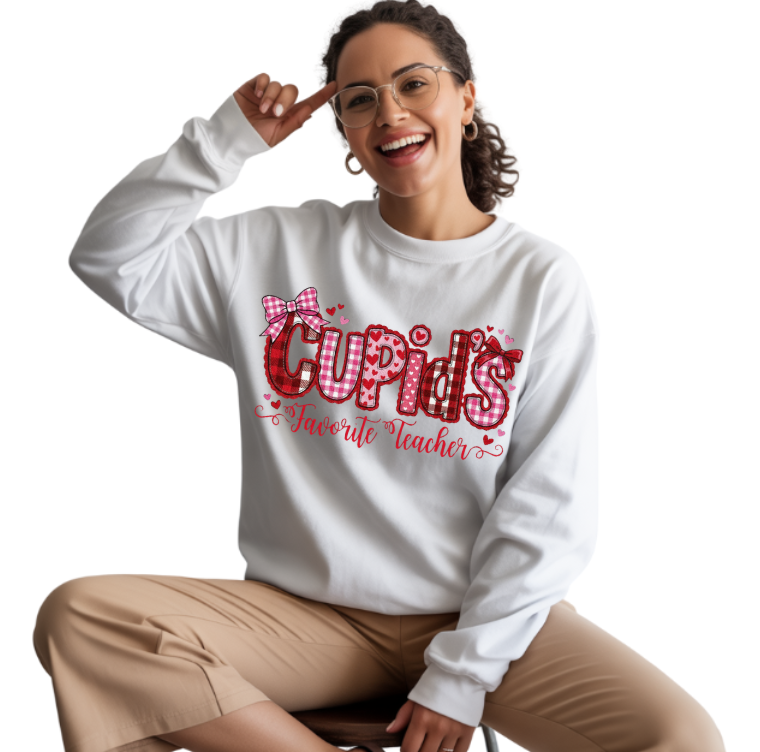 Woman wearing a white sweatshirt with 'Cupid's Favorite Teacher' text and a bow graphic.