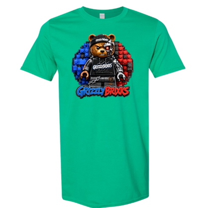 A bright green short-sleeve t-shirt with a colorful graphic of a teddy bear wearing a black cap and black outfit, set against a blue and red pixelated circle, with the text 'Grizzly Brixks' below.
