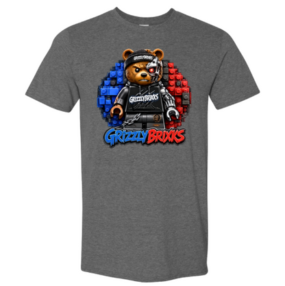 A heather gray short-sleeve t-shirt featuring a graphic of a bear character wearing a black cap and black outfit, set against a background of blue and red building blocks, with the text 'Grizzly Brixks' below.