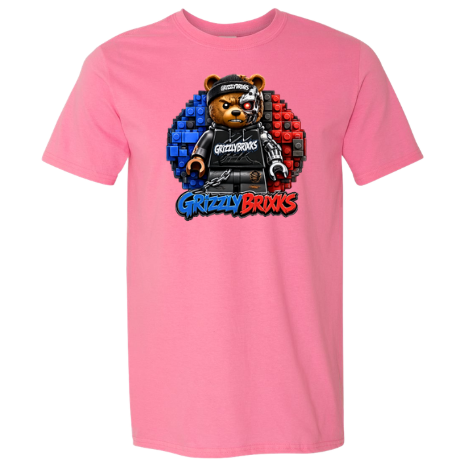 A pink short-sleeve crewneck t-shirt featuring a central graphic of a teddy bear wearing a black hoodie and cap, set against a blue and red pixelated circle, with the text 'Grizzly Brixks' below.