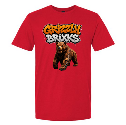 A red short-sleeve crewneck t-shirt featuring a graphic print of a brown bear under the text 'Grizzly Brixks' in orange and white graffiti-style lettering.