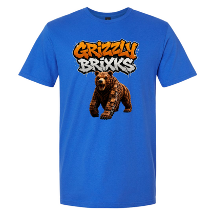 A bright blue short-sleeve t-shirt with a graphic on the chest featuring the text 'Grizzly Brixks' in an orange and white graffiti style above a pixelated brown bear.